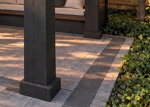 Detail: timber post base and charcoal paver border framing the patio